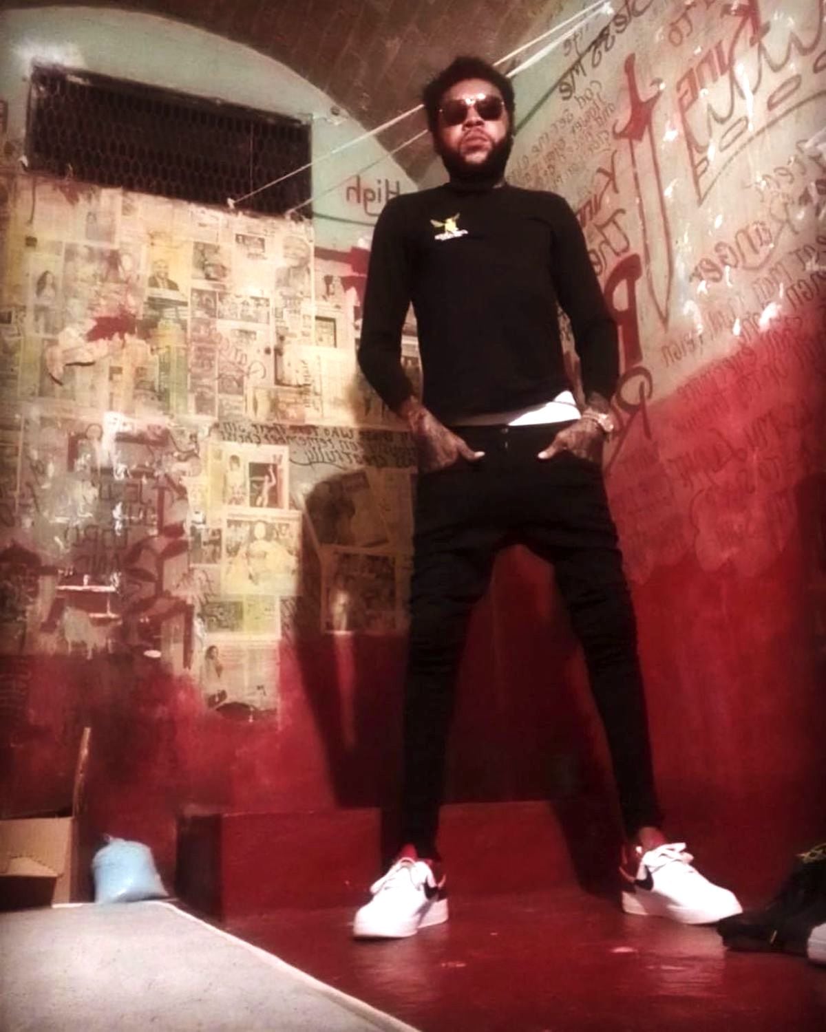 Vybz Kartel Wears Long-Sleeve Shirt, Skinny Jeans And Air Force One Sneakers In New Prison Photo